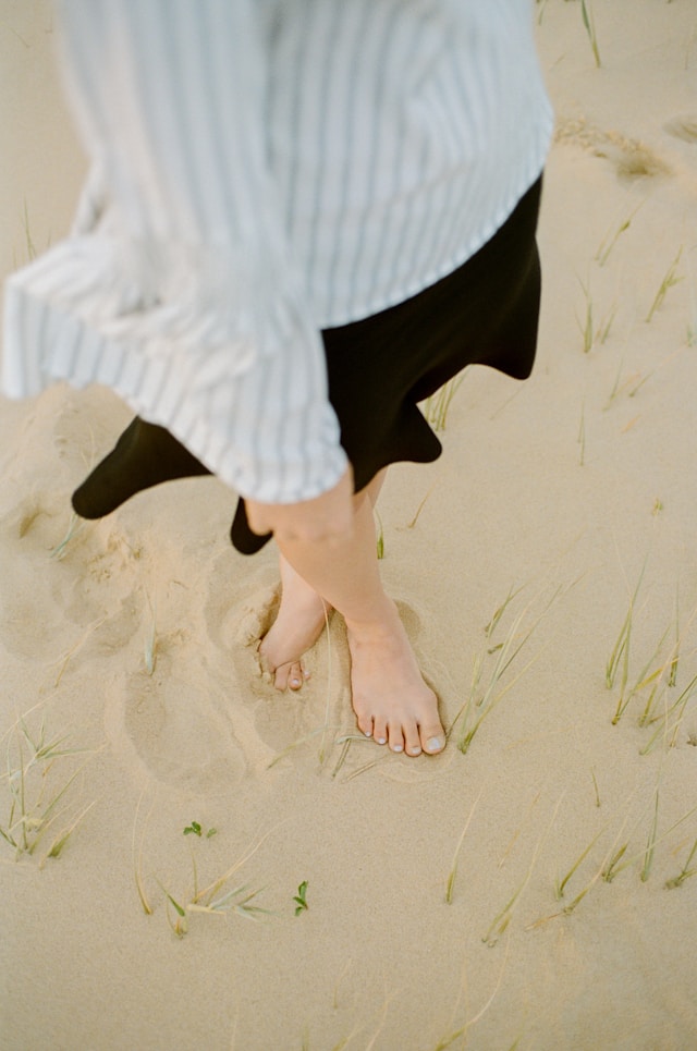 beautiful toe, make up toe, color toe. lady standing on the sand, showing beautiful toes.